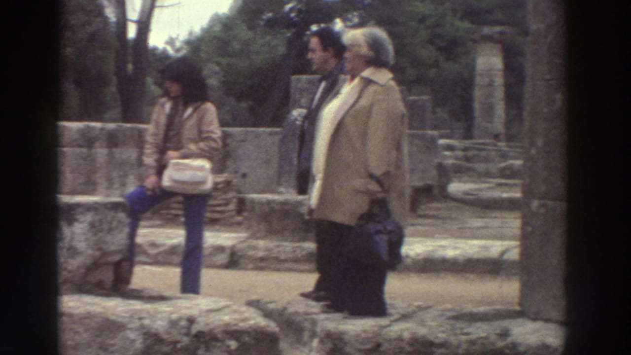Two or three tourists in 1970s clothing standing near ancient stone ruins, trees and stonework visible behind.