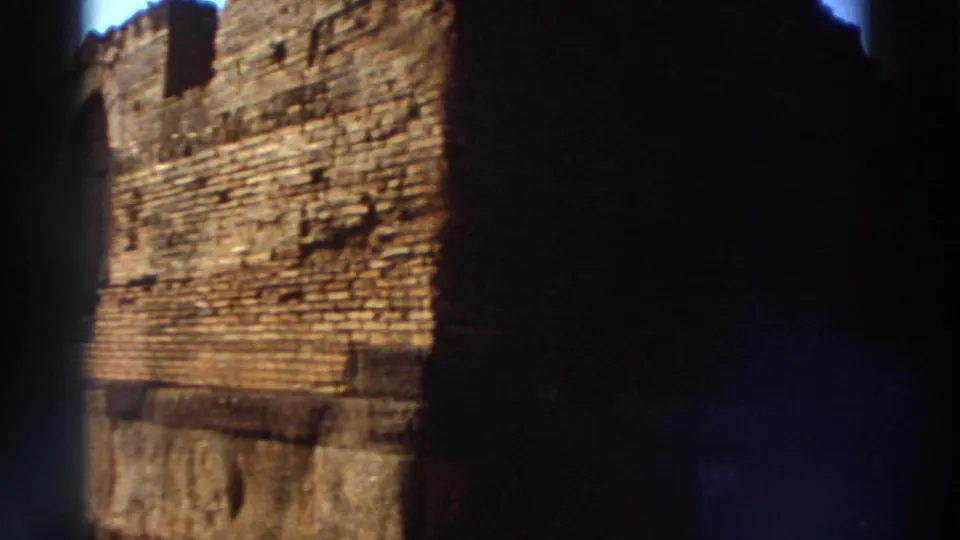 Close-up of large ancient brick and stone wall under bright sunlight at a Greek ruin site, circa 1976, with 8mm gate vignetting on both sides.