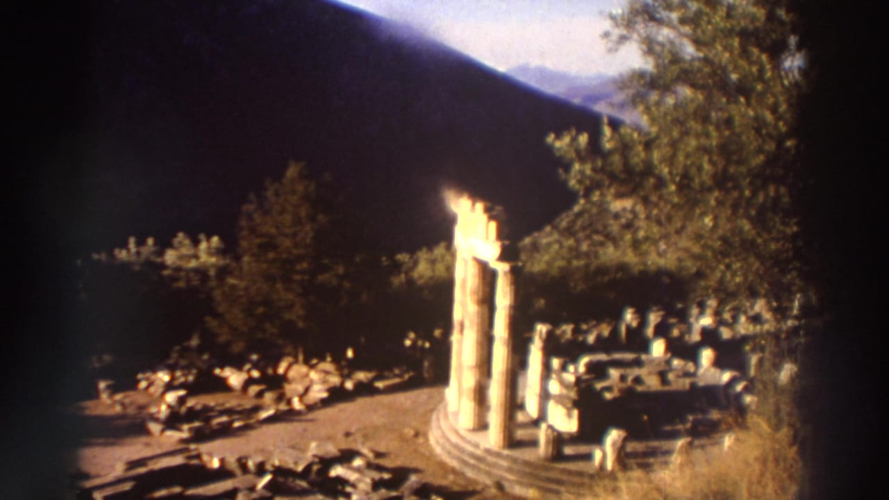 Three standing columns on a circular stepped base at a Greek archaeological site, 1976, 8mm home movie with warm tones and vignetting.