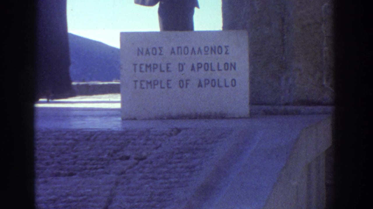 Trilingual stone marker identifying the Temple of Apollo in Greek, French, and English; partial silhouette of a figure visible above, Greece, 1976.