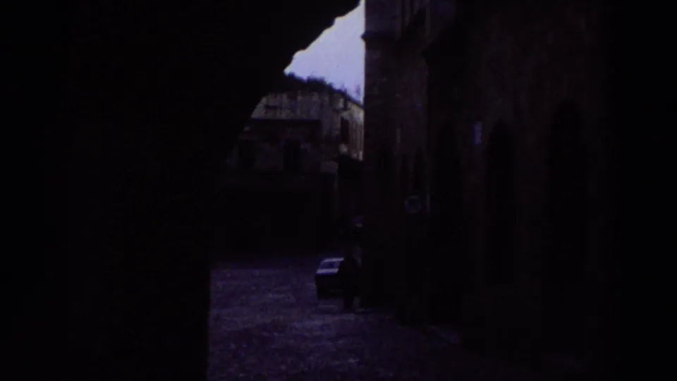 Dark stone archway passage in a Greek old town, likely captured mid-walk during a 1976 travel visit; heavily underexposed.