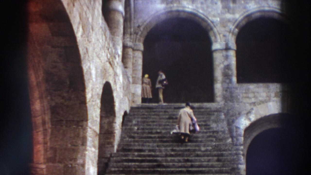 Stone arched entryways with wide stone steps and two robed figures ascending in dim light.