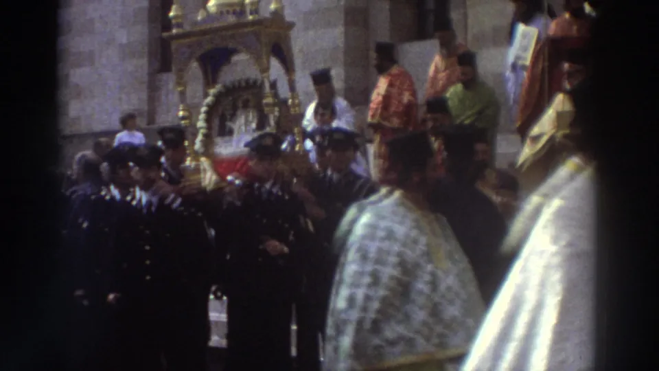 Gilded portable icon shrine surrounded by clergy in red vestments and uniformed honor guards during a Greek Orthodox procession, circa 1976.