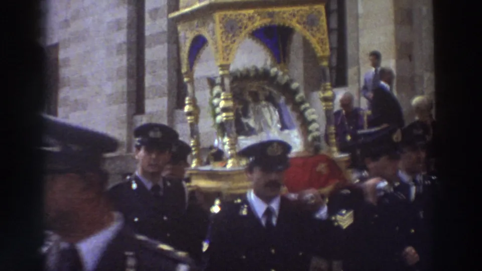 1976 Greece home-movie close view of uniformed procession participants with an ornate gold reliquary and religious figure behind them.