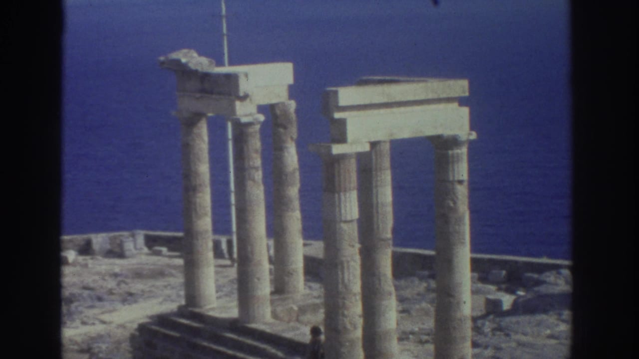 1976 Greece 8mm view of ancient seaside columns and rectangular stone lintels against the blue sea.