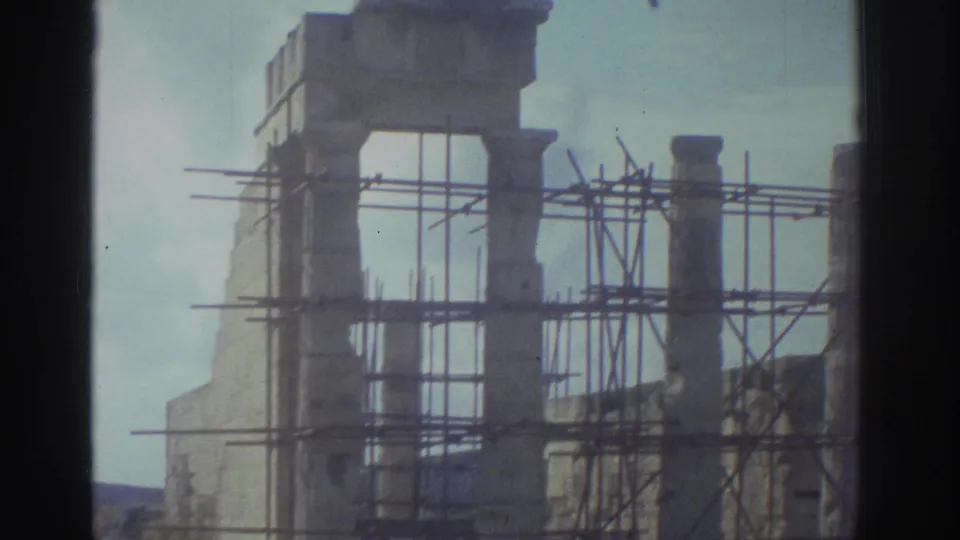 1976 Greece 8mm view of a seaside column restoration area with scaffolding around weathered stone remains.