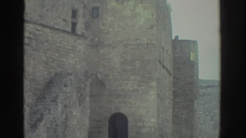 1976 Greece footage appears to show stone village buildings and an arched doorway along a cobblestone street.