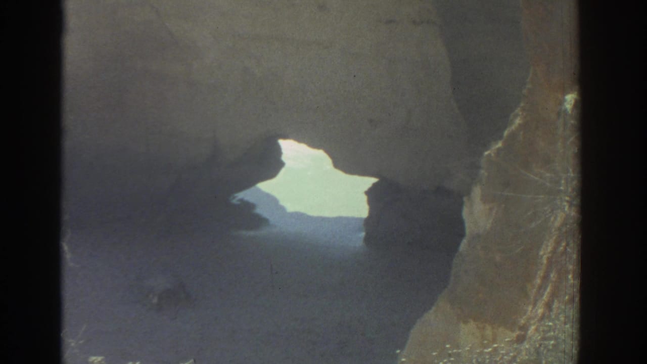 Shadowed rock opening with bright daylight beyond and dark stone edges.