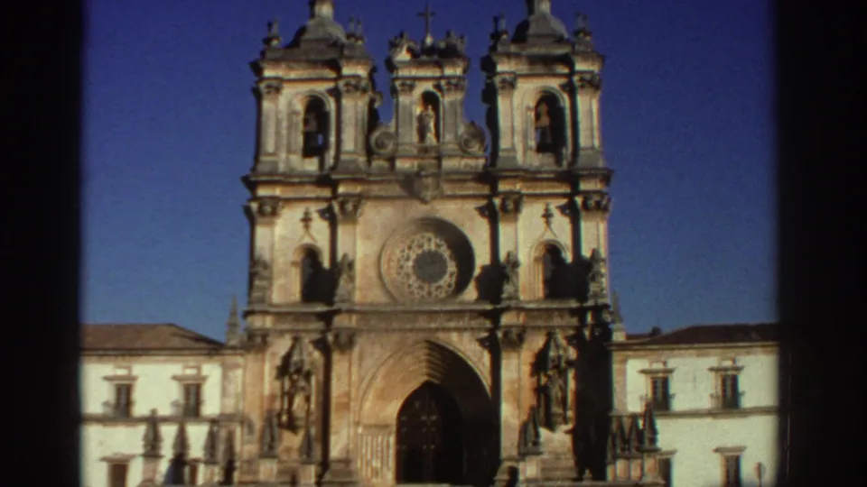 1976 Greece 8mm travel frame showing the front of an ornate cathedral with twin bell towers, a rose window, and sculptural stone details.