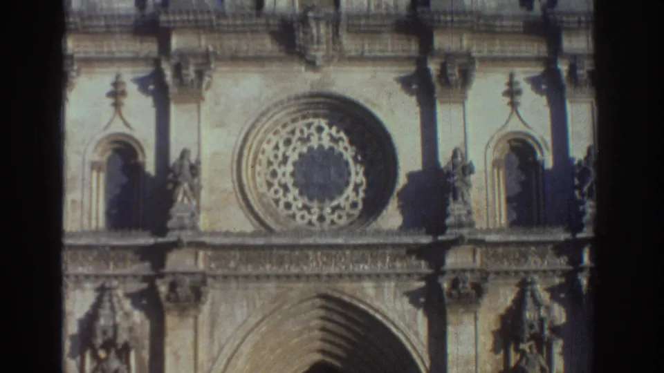 Soft 8mm view of a Greek cathedral facade in 1976, centered on the rose window, upper tracery, and pointed doorway below.
