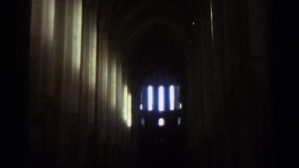 1976 Greece travel footage appears to show a dim cathedral nave with tall stone arches and glowing windows in the distance.