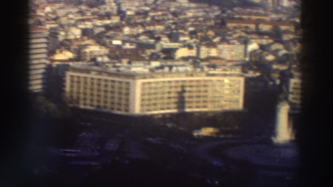 City panorama with a large rectangular high-rise building in the foreground.