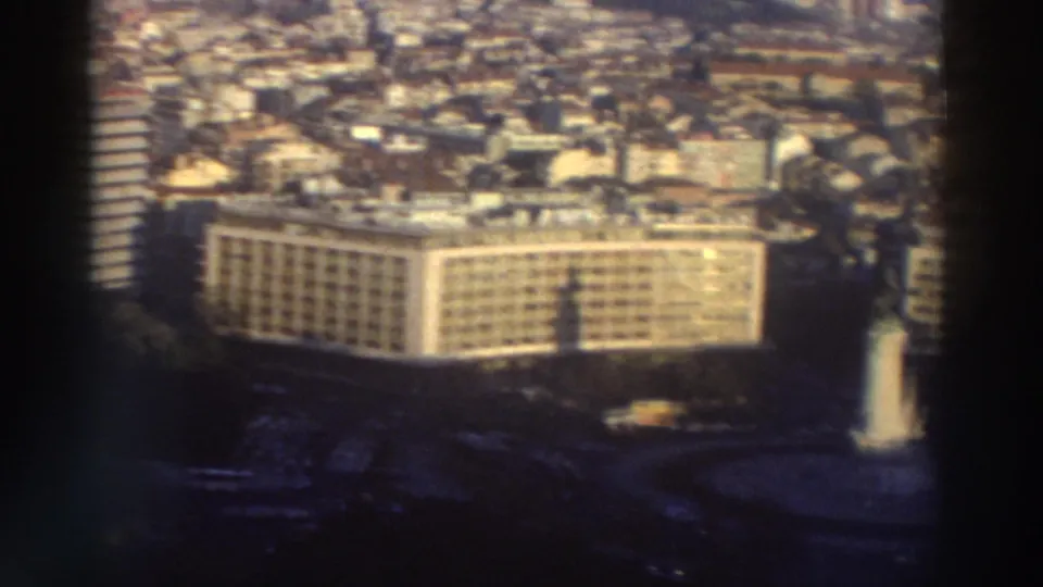 1976 Greece city view from above, with a large modern block, surrounding streets, and dense buildings extending into the distance.