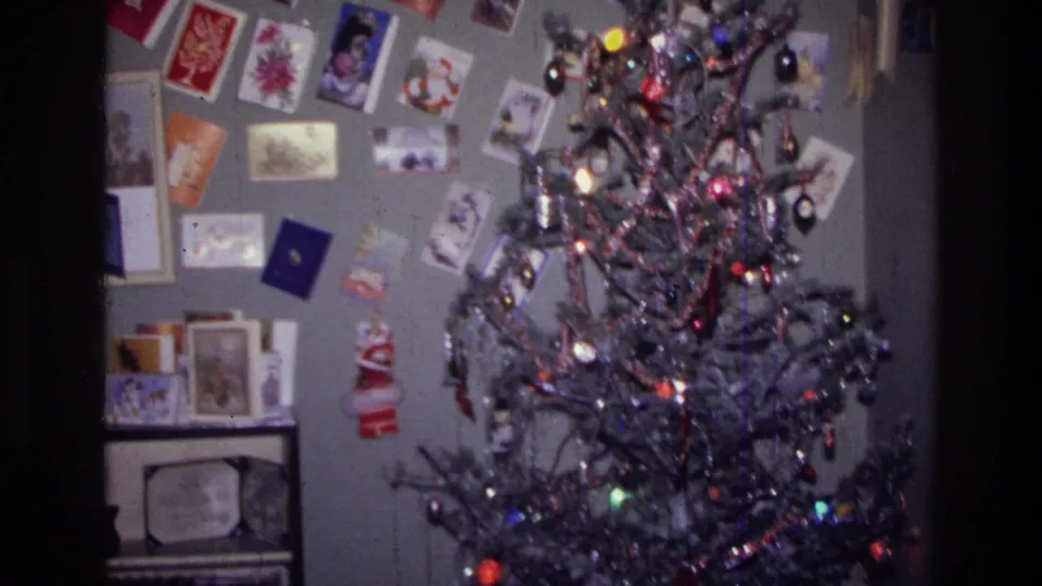 1976 Harlem home interior showing a lit Christmas tree, ornaments, tinsel, and a dense wall display of holiday cards.