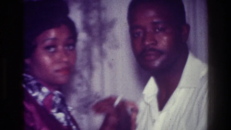 At the end of the 1976 Harlem clip, both dancers glance toward the camera during a close indoor dance beside patterned curtains.