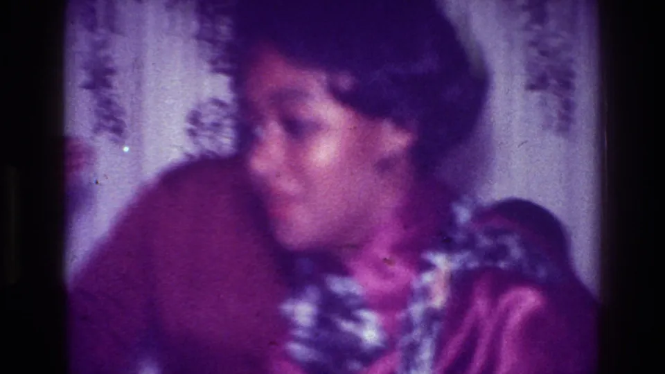 A young woman in a purple top moves in the Harlem home party setting, framed by patterned curtains and soft purple-tinted 8mm texture.