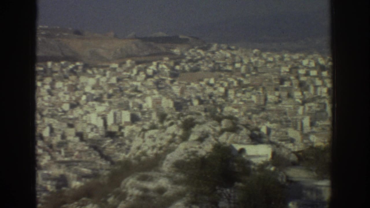 1976 Tel Aviv panorama with white and beige buildings filling the frame beyond rough hillside vegetation.