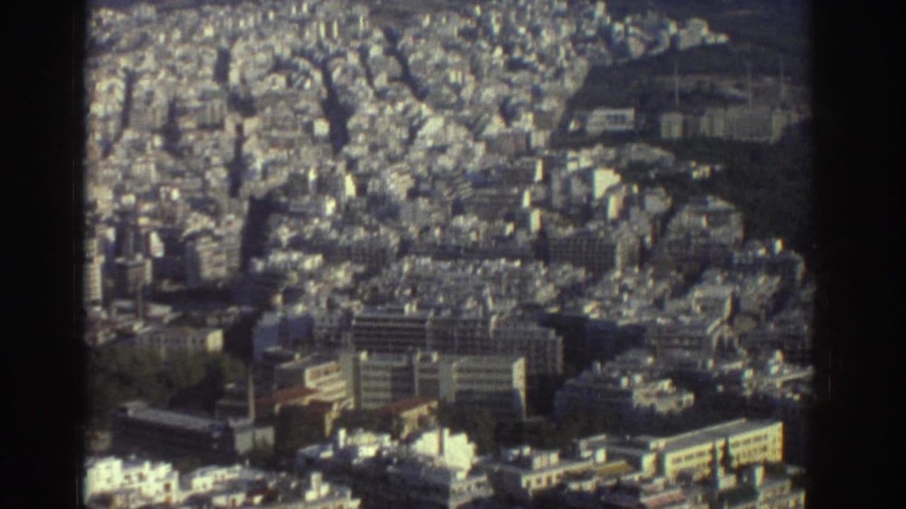 1976 Tel Aviv aerial-style view showing dense mid-rise buildings, street grids, and greenery on soft 8mm film.