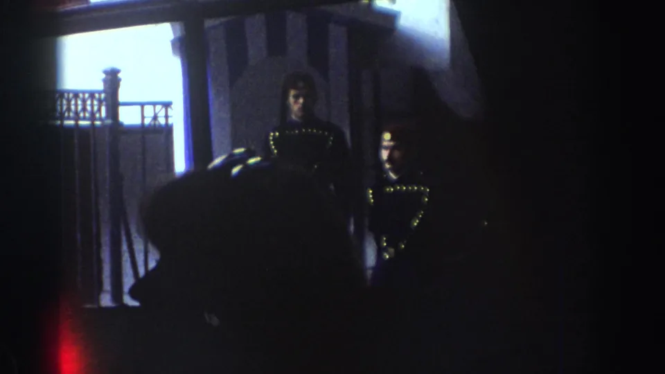 The final frame holds on a dimly lit interior with uniformed figures near a bright doorway, likely from the same 1976 Israel travel reel.