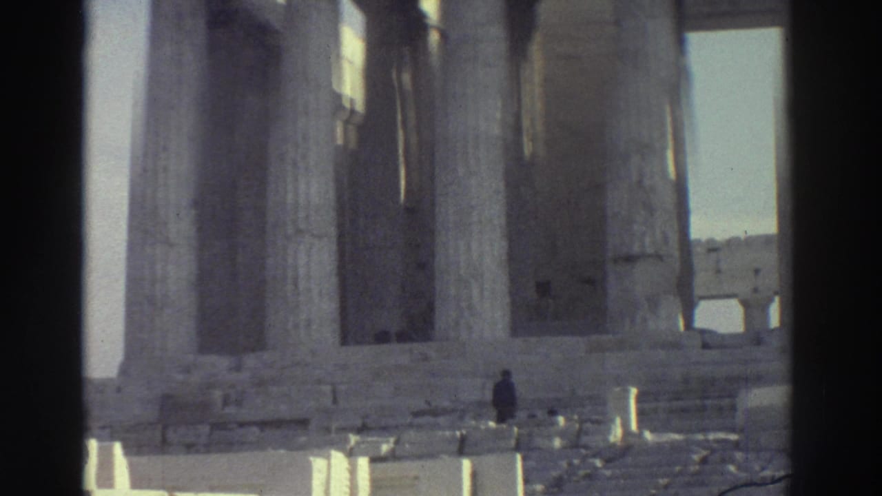 1976 8mm frame of ancient stone columns and ruins in Israel, with a small visitor figure walking among the pale masonry.