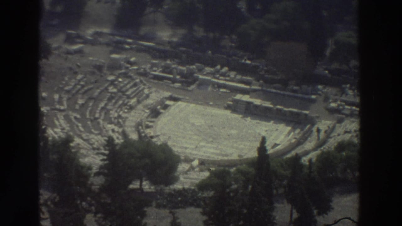 Overhead view of a stone amphitheater-like ruin with tiered seating and trees around it.