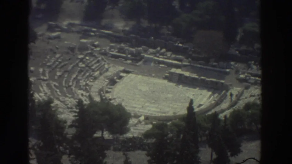 1976 8mm travel footage shows an overhead view of ancient stone ruins in Israel, with tiered seating and a pale circular arena.
