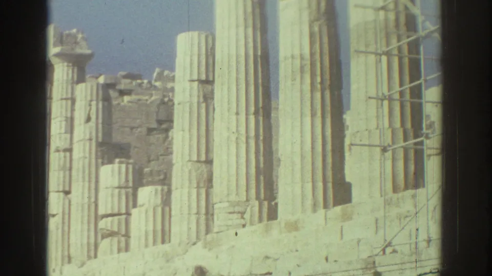 1976 Tel Aviv home-movie frame showing sunlit pale columns, weathered masonry and scaffold poles at an archaeological site.