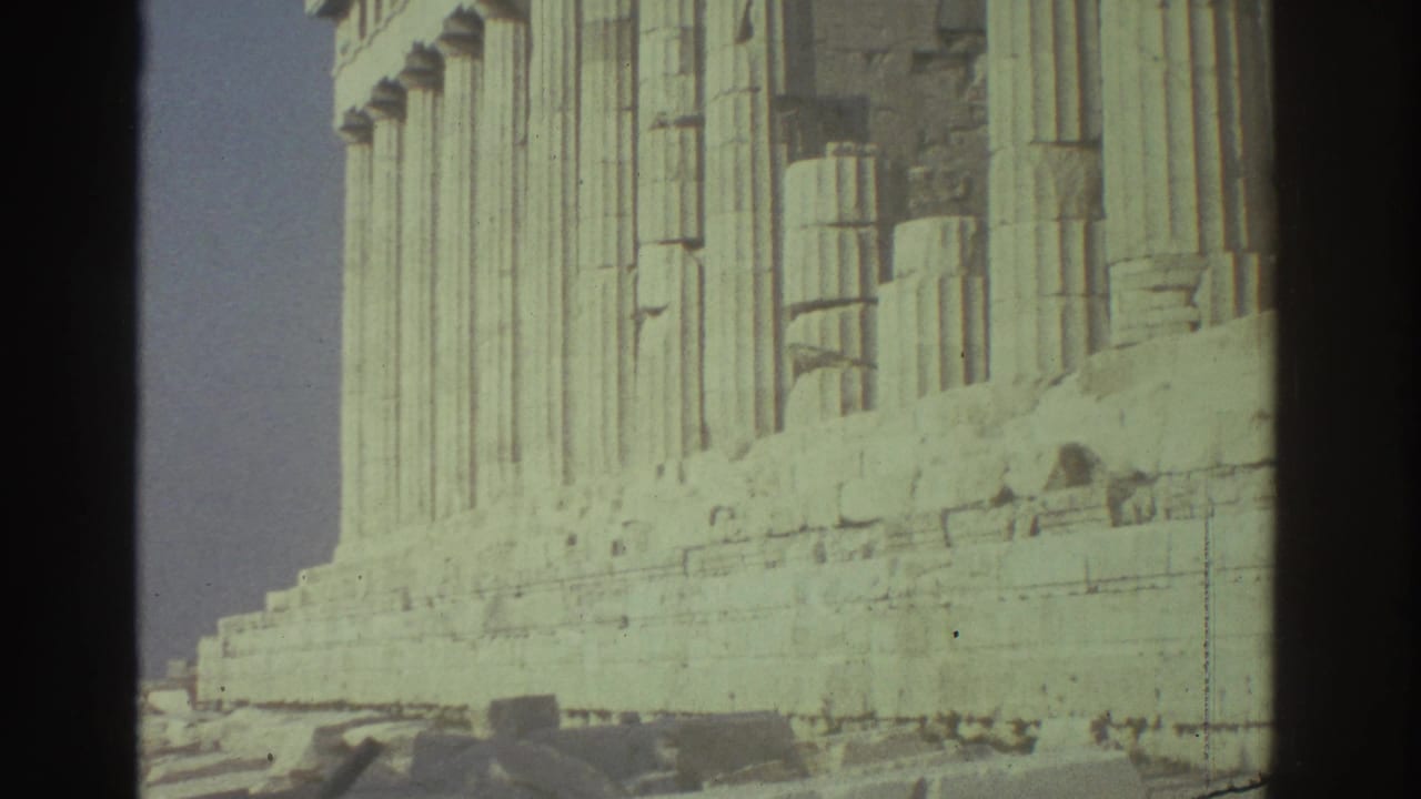 Close view of fluted stone columns and a weathered base at an ancient ruin site.