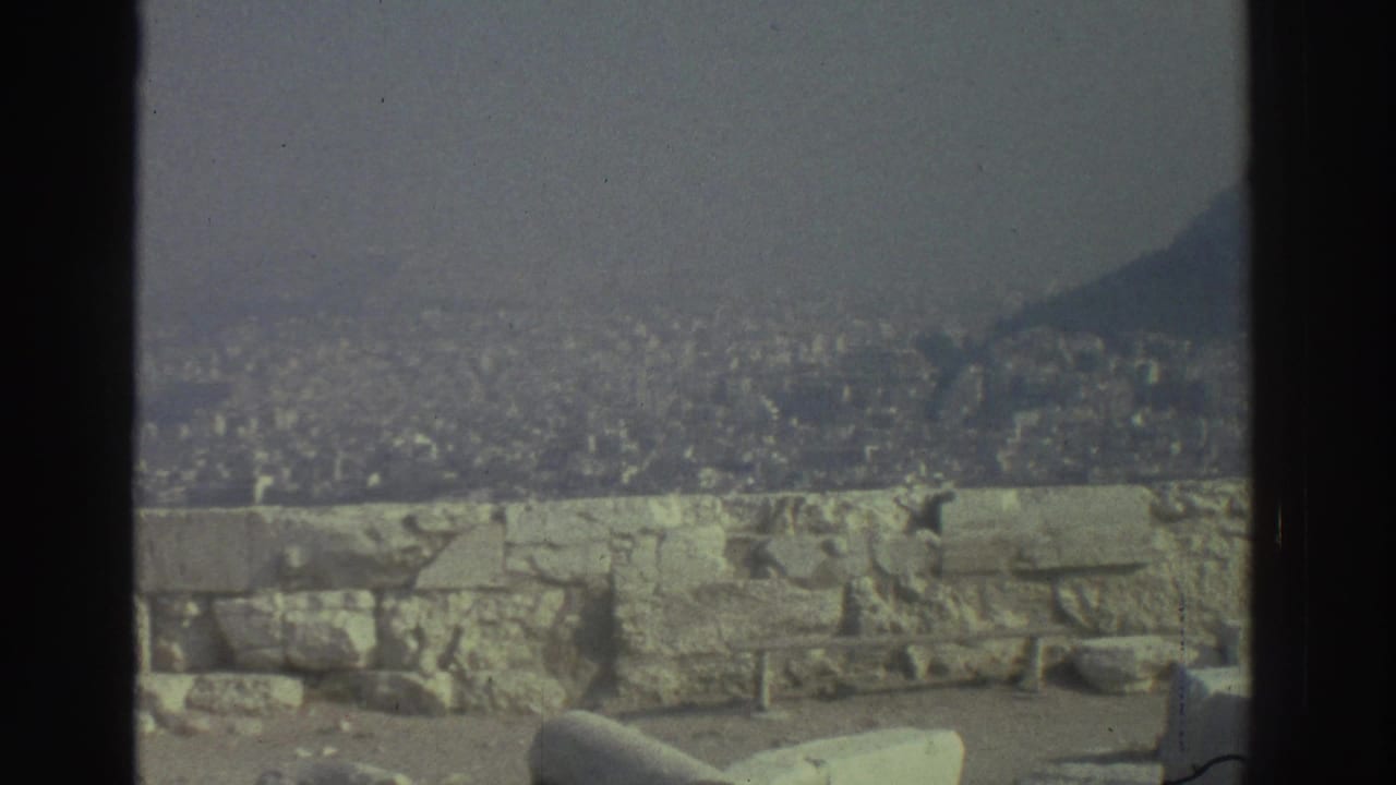 Urban valley seen over a low stone wall and ruin fragments.