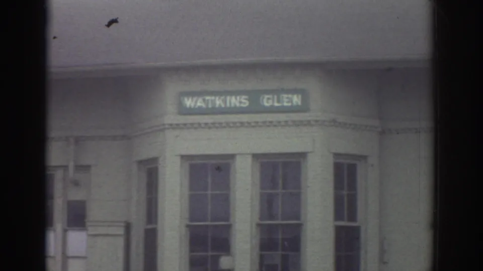 1976 Watkins Glen, New York home-movie frame showing a Watkins Glen sign above windows on a building facade.