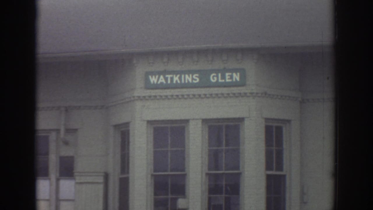 1976 Watkins Glen, New York frame with a close view of a Watkins Glen sign mounted above building windows.