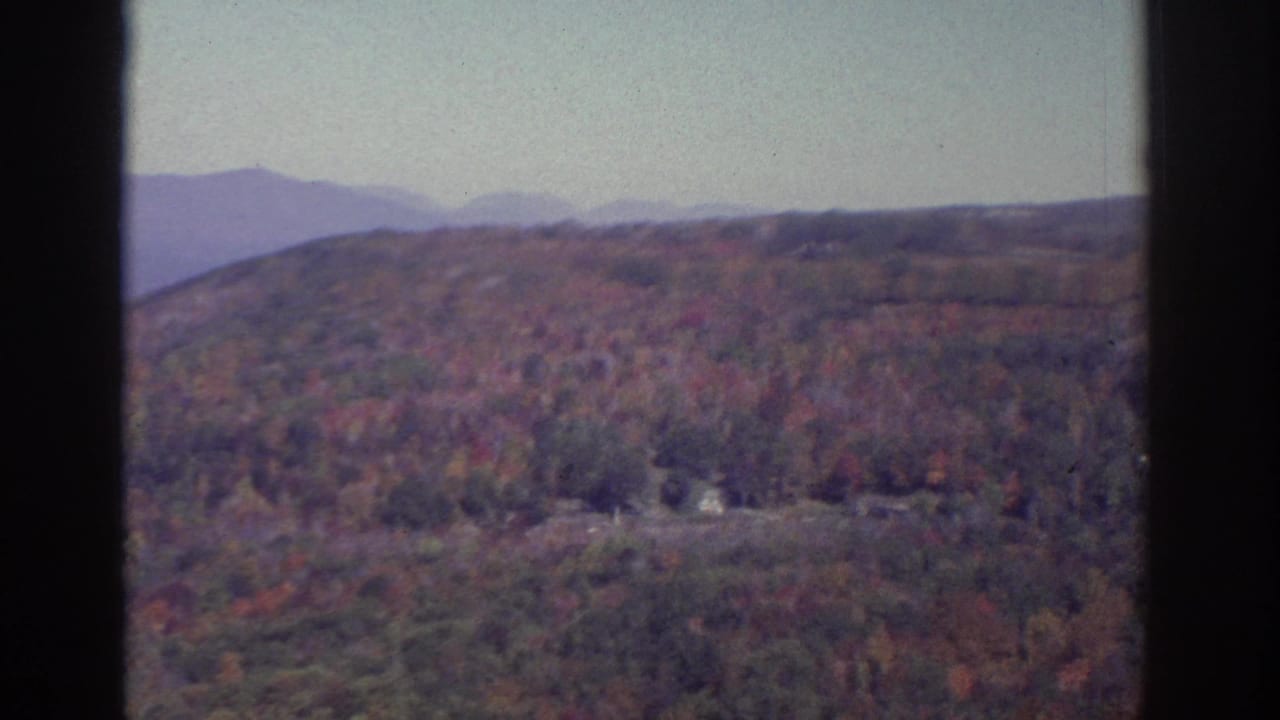 Watkins Glen-area autumn panorama on 8mm film, showing wooded hills, muted fall color, and distant ridgelines.