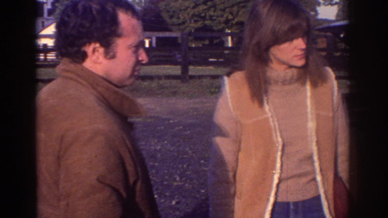 In 1976 Watkins Glen home-movie footage, a man in a brown jacket faces a woman in a tan shearling vest near a fence.