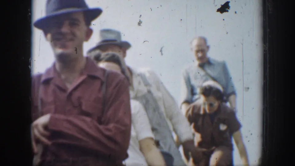 1937 California home-movie close view of adults in brimmed hats and shirts moving across pale rocky terrain.
