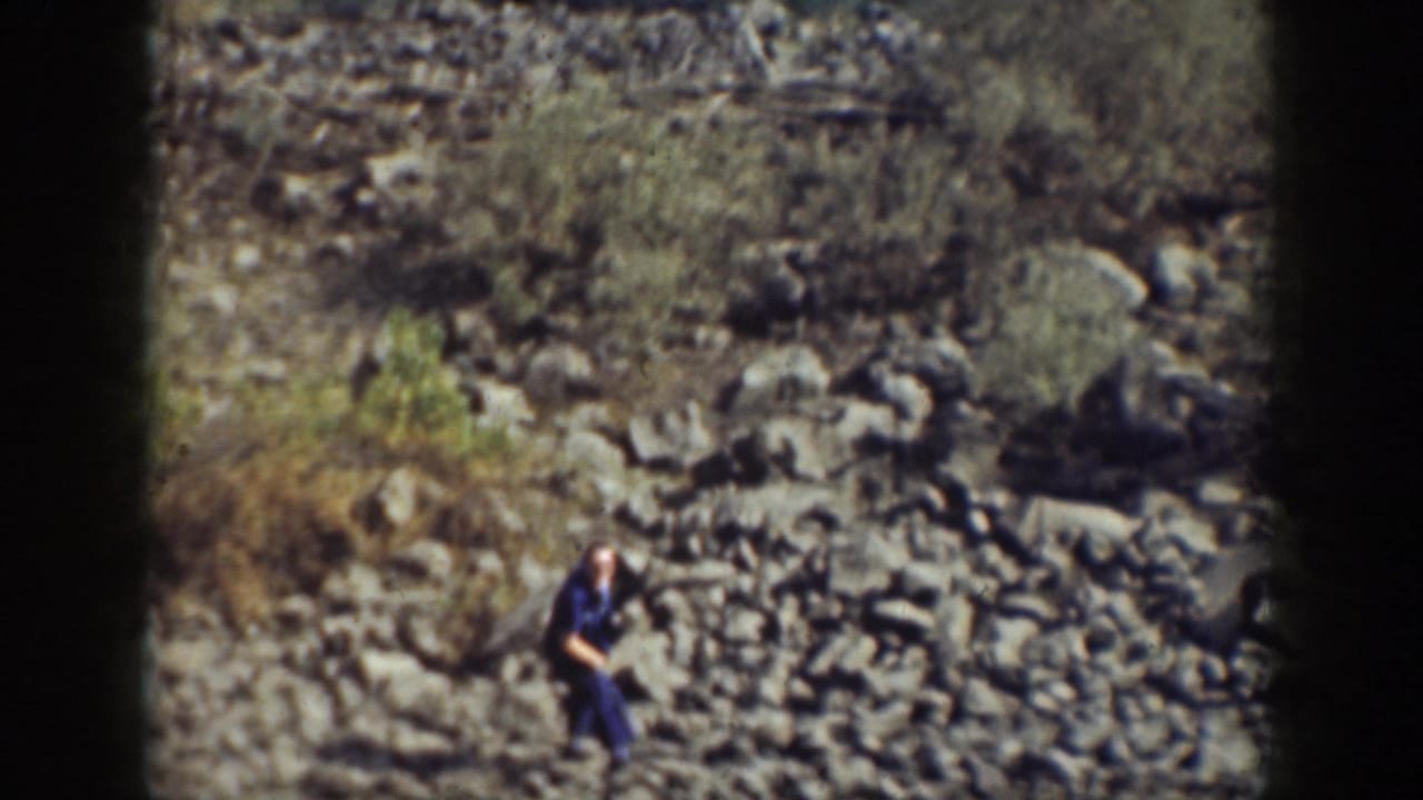 A distant figure in dark clothing appears among rocks on a California hillside in this 1937 home-movie frame.