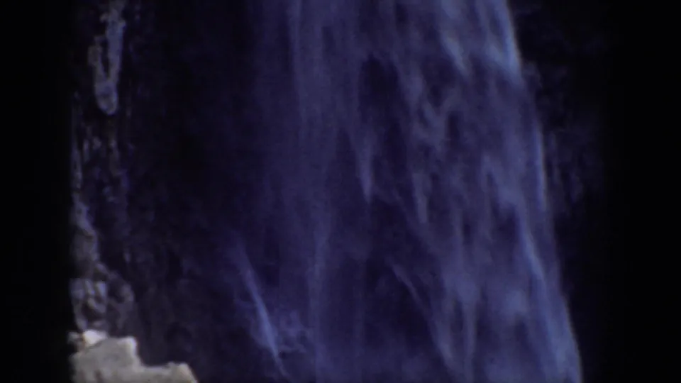 1937 California 8mm frame showing a close curtain of falling water framed by dark cliff shadows.