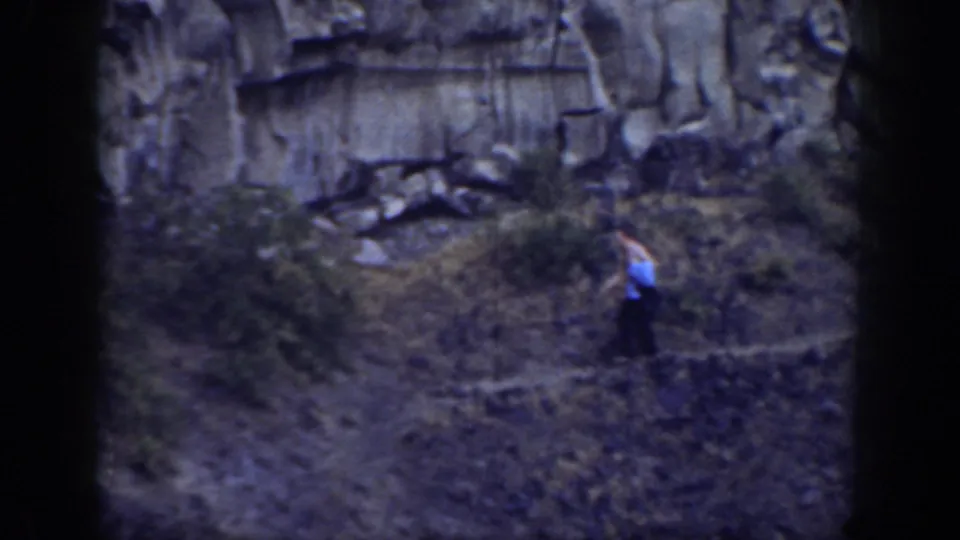 A lone hiker in a light shirt and dark pants moves across a brushy California hillside in the archival 1937 clip.