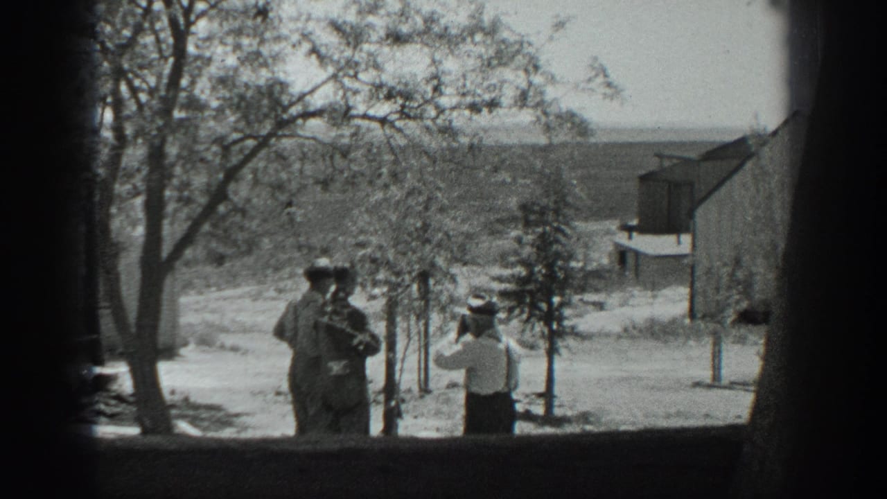 Three men in 1937 California stand beside young trees on a rural property, with a barn-like building and distant fields behind them.