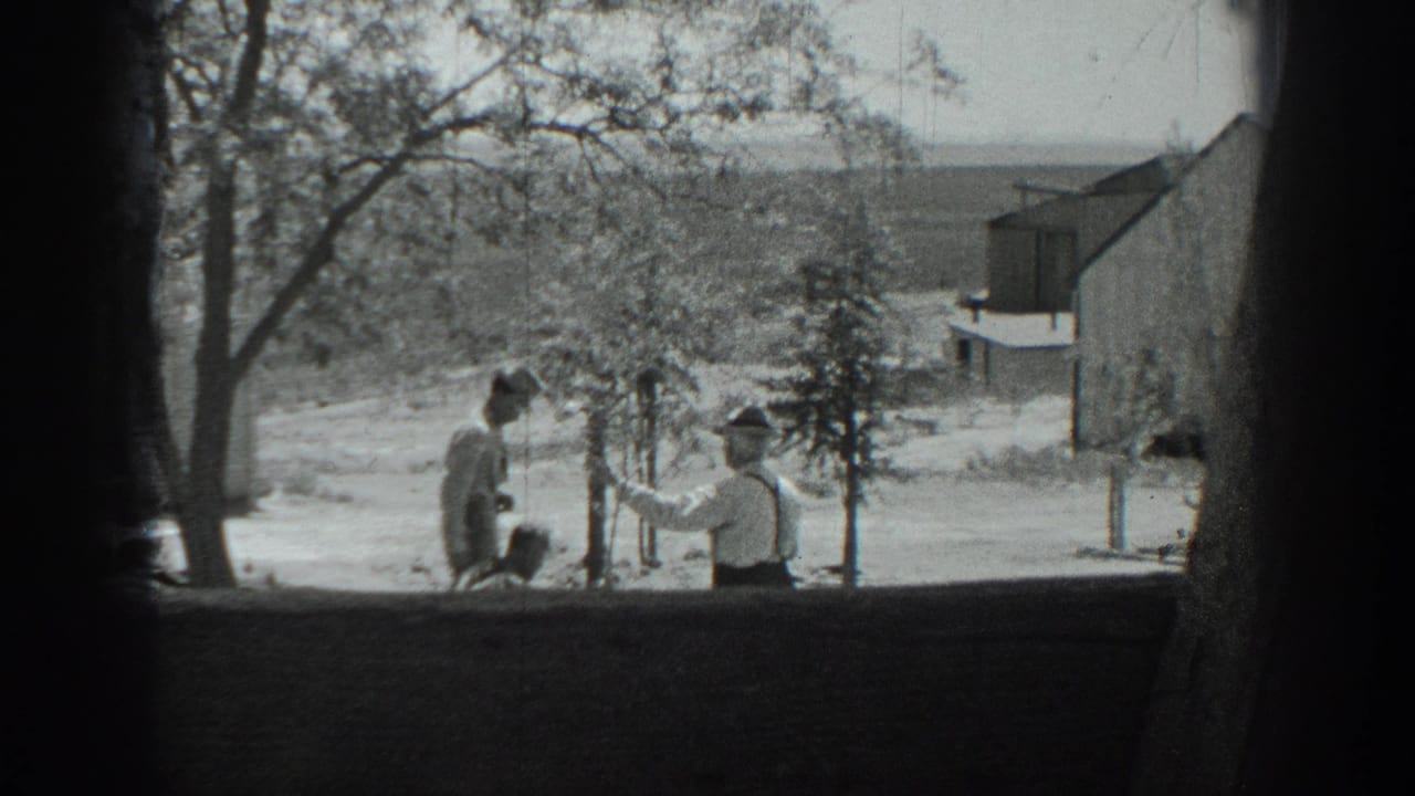1937 California 8mm frame showing two men outdoors near trees, open ground, and a small structure in a rural setting.