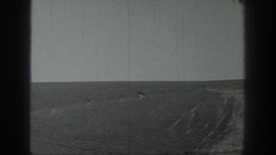1937 California 8mm frame showing a stark open landscape or coastal plain with a flat horizon and overcast sky.