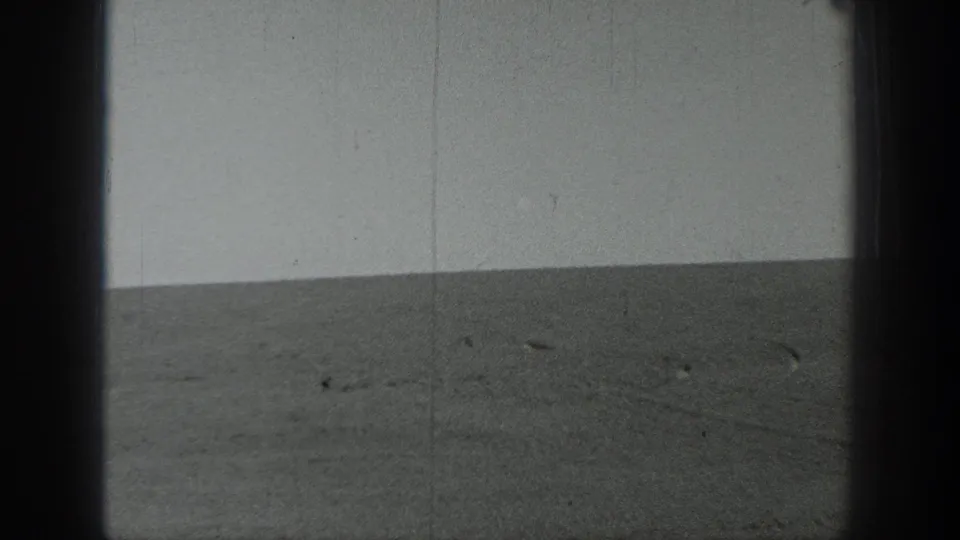 1937 California home-movie frame showing an empty plain or shoreline with a slightly tilted horizon and grainy black-and-white texture.
