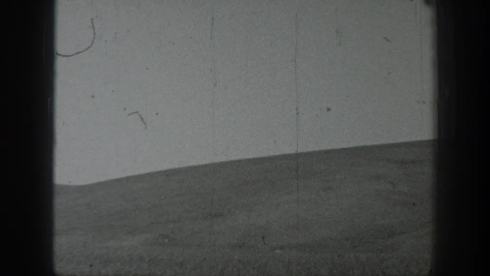 Wide 1937 California home-movie frame of cultivated farmland, with a soft horizon and heavy vertical 8mm frame borders.