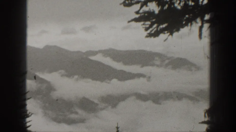1938 California 8mm frame showing mountain ridges with clouds drifting through valleys.
