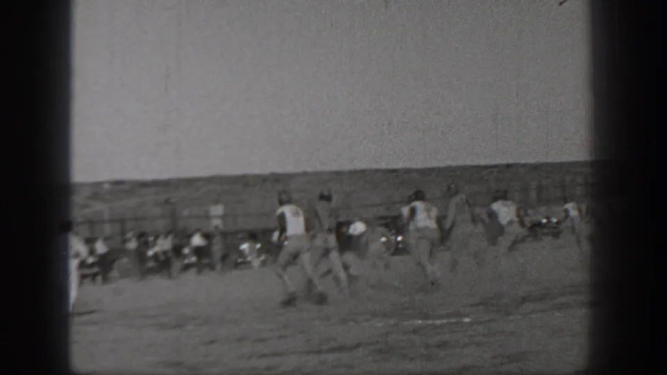 1938 Washington 8mm footage appears to show a football play in progress, with uniformed players running across a field and spectators in the background.