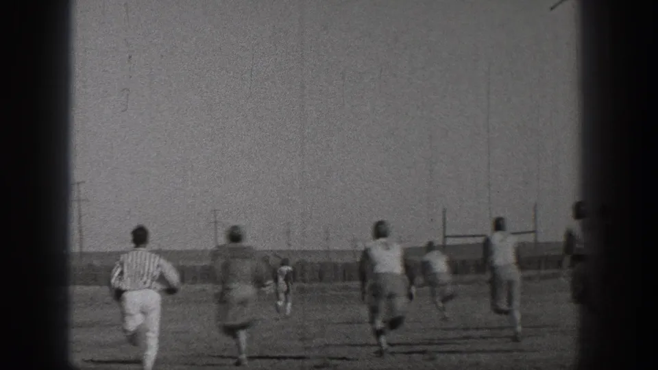 Washington 1938 football action with several players running downfield, a striped referee following, and goal posts visible at right.