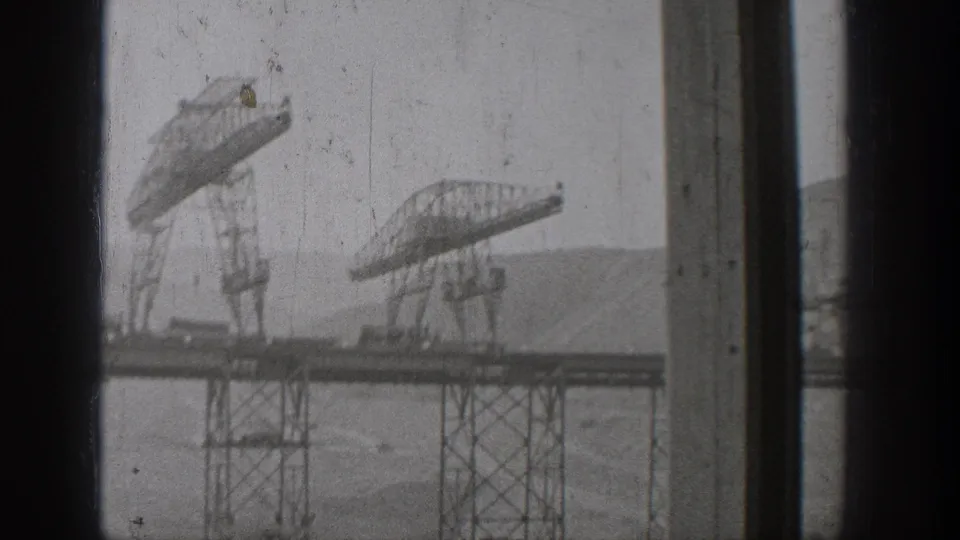 1938 Washington 8mm frame showing steel truss construction over water, partly obscured by window mullions and film wear.
