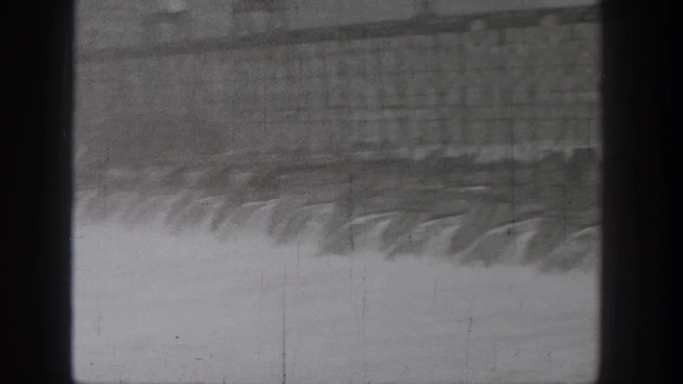 1938 Washington frame with water rushing below a large bridge or spillway, partially obscured by a central dark vertical band.