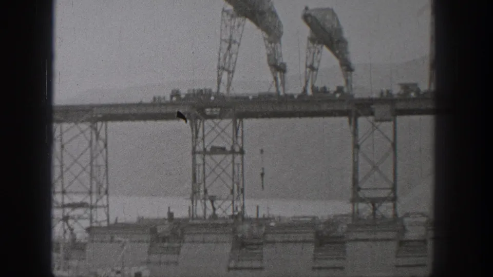 Washington 1938 home-movie frame with gantry towers and crane-like equipment viewed from a static distance.