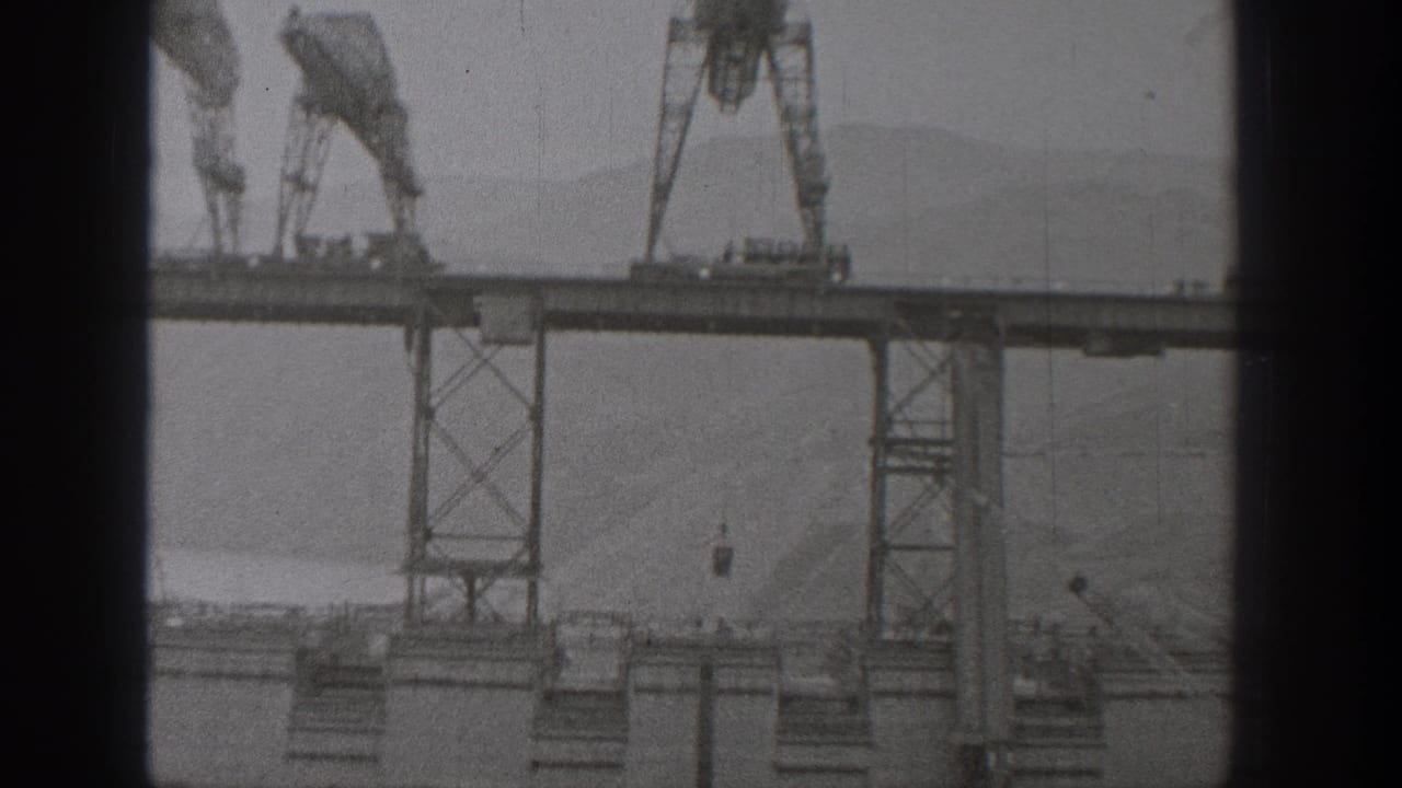 Gantry cranes stand on an elevated bridge deck above steel supports.