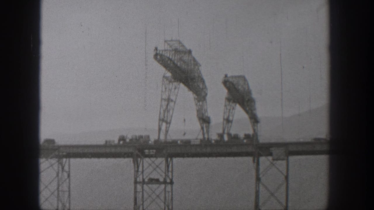 1938 Washington 8mm frame of two arched construction rigs on a bridge deck, partially obscured by dark vertical window or film-frame edges.